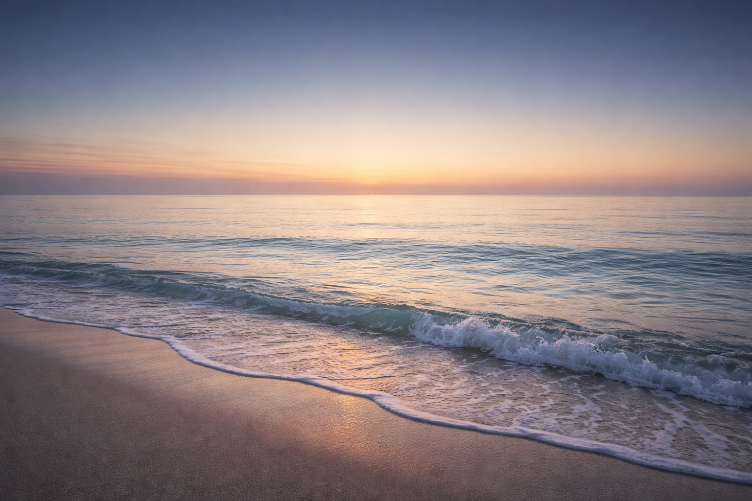 夜明け前の静かな海。穏やかな波と、群青から淡い金色へと移ろう空が広がっている